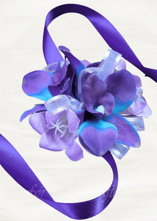 Artificial wedding wrist corsage with purple and blue faux orchids, pale feathery sprigs and trailing dark ribbons. For formals, proms and ball occasions. Made in Melbourne by Flowers For Ever After, shipping Australia and Worldwide.