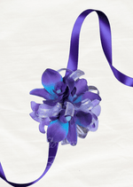 Artificial wedding wrist corsage, angled view of purple and blue faux orchids with pale feathery accents and dark ribbons. For formals, proms and ball occasions. Made in Melbourne by Flowers For Ever After, shipping Australia and Worldwide.