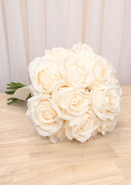 Artificial wedding bridal bouquet laid sideways, showing clustered ivory faux roses and layered petals. Made in Melbourne by Flowers For Ever After, shipping Australia and Worldwide.