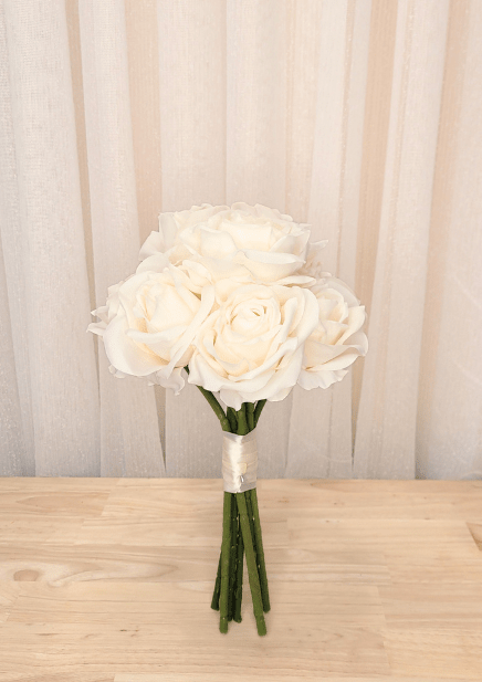 Artificial wedding bridesmaid bouquet with ivory faux roses, ivory ribbon wrapping and gathered green stems. Made in Melbourne by Flowers For Ever After, shipping Australia and Worldwide.