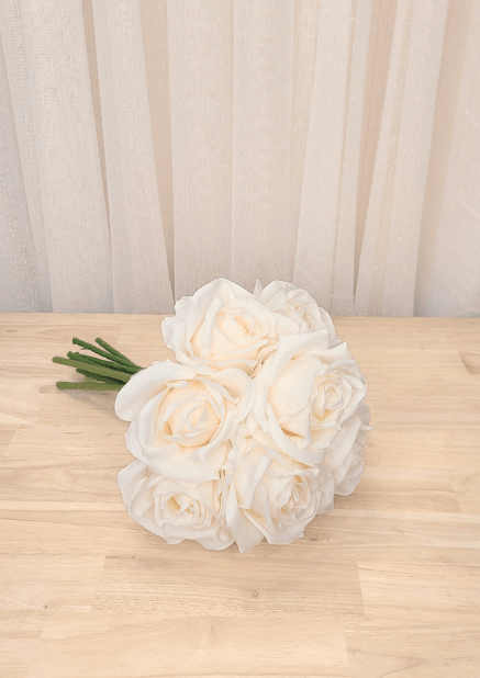 Artificial wedding bouquet laid sideways, showing clustered ivory faux roses and layered petals. Made in Melbourne by Flowers For Ever After, shipping Australia and Worldwide.