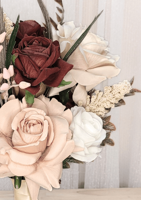 Artificial wedding bouquet close-up with terracotta, beige and ivory faux roses, pale sprigs and pointed leaves. Made in Melbourne by Flowers For Ever After, shipping Australia and Worldwide.