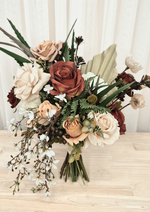 Artificial wedding bouquet, front view of terracotta and beige faux roses, pale fan leaf, dark sprigs and trailing white blossoms. Made in Melbourne by Flowers For Ever After, shipping Australia and Worldwide.