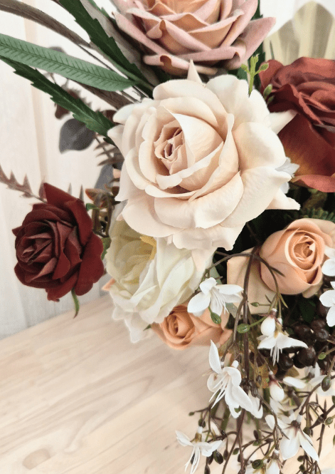 Artificial wedding bouquet close-up with beige and terracotta faux roses, peach rosebuds and trailing white blossoms. Made in Melbourne by Flowers For Ever After, shipping Australia and Worldwide.
