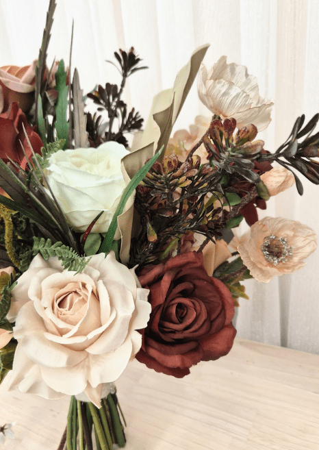 Artificial wedding bouquet detail with terracotta, beige and ivory faux roses, pale poppies, dark branching sprigs and fan leaf. Made in Melbourne by Flowers For Ever After, shipping Australia and Worldwide.