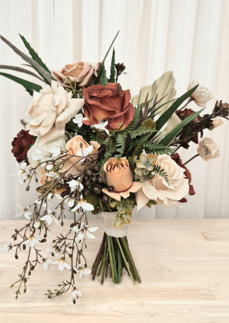 Artificial wedding bouquet with terracotta, beige and ivory faux roses, fern-like leaves, pale fan leaf and trailing white blossoms. Made in Melbourne by Flowers For Ever After, shipping Australia and Worldwide.