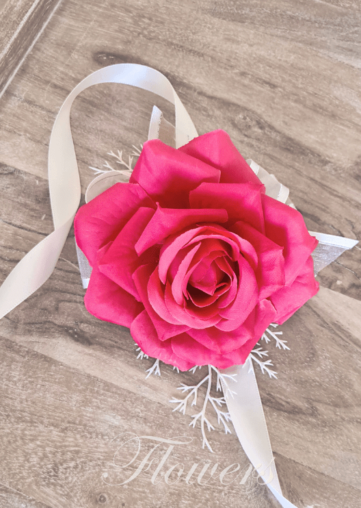 Artificial wedding wrist corsage with hot pink faux roses, pale filler flowers, green leaves and ivory ribbons. For formals, proms and ball occasions. Made in Melbourne by Flowers For Ever After, shipping Australia and Worldwide.