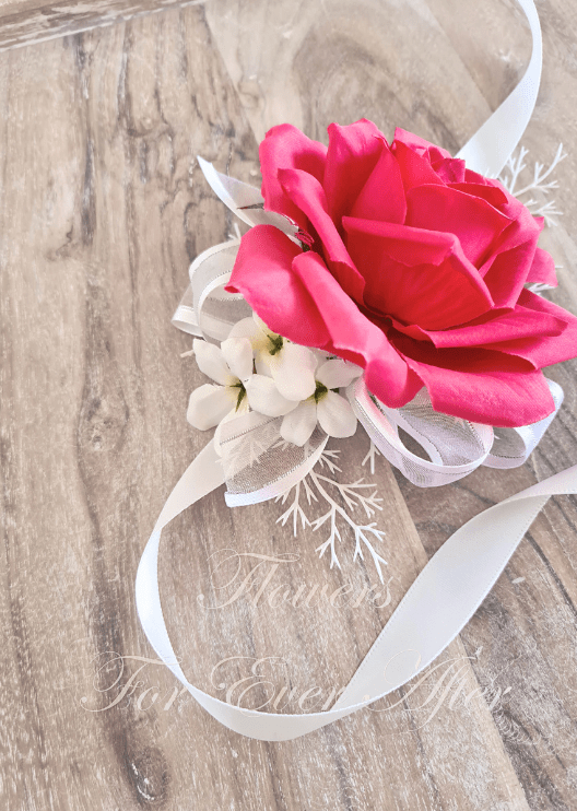 Artificial wedding wrist corsage close-up with hot pink faux roses, pale flowers and ivory ribbons. For formals, proms and ball occasions. Made in Melbourne by Flowers For Ever After, shipping Australia and Worldwide.