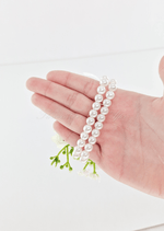 Artificial wedding corsage bracelet detail showing a double-row pearl-style band held across a hand beneath faux flowers. For formals, proms and ball occasions. Made in Melbourne by Flowers For Ever After, shipping Australia and Worldwide.