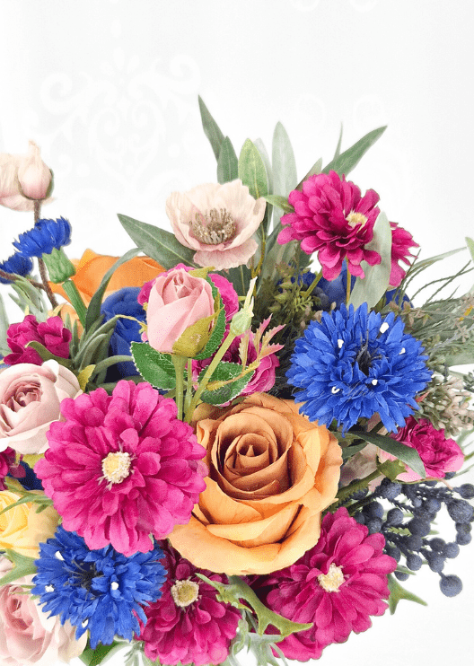 Artificial wedding bouquet detail showing orange faux rose, blue cornflower, magenta dahlias, blush rosebuds and pale pink poppy. Made in Melbourne by Flowers For Ever After, shipping Australia and Worldwide.