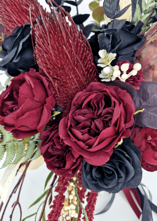 Artificial wedding bouquet detail showing burgundy and black faux roses, burgundy spiky blooms and pale filler flowers. Made in Melbourne by Flowers For Ever After, shipping Australia and Worldwide.