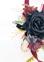 Artificial wedding wrist corsage close-up with a black faux rose, burgundy flowers and black and burgundy ribbon loops. For formals, proms and ball occasions. Made in Melbourne by Flowers For Ever After, shipping Australia and Worldwide.