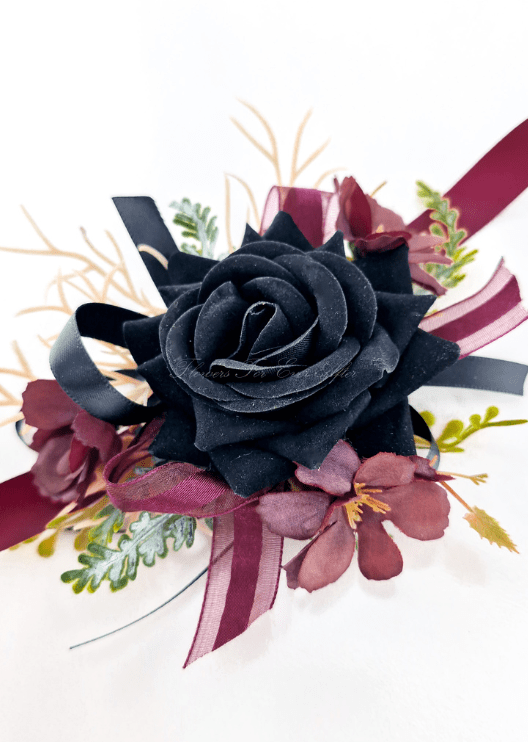 Artificial wedding wrist corsage, top view of a black faux rose, burgundy flowers, pale sprigs and black ribbons. For formals, proms and ball occasions. Made in Melbourne by Flowers For Ever After, shipping Australia and Worldwide.