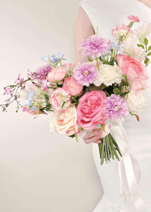 Artificial wedding bridal bouquet, handheld angled view of pink faux roses, lilac daisies, white flowers and green sprigs. Made in Melbourne by Flowers For Ever After, shipping Australia and Worldwide.