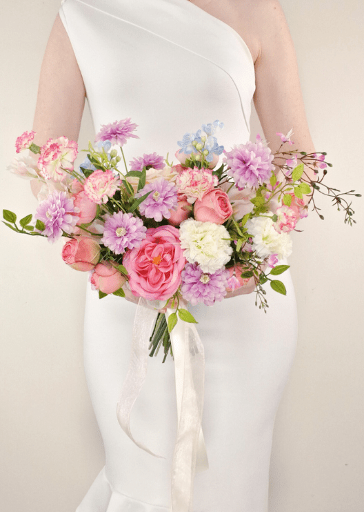 Artificial wedding bridal bouquet, handheld front view of pink faux roses, lilac daisies, white blooms and branching green sprigs. Made in Melbourne by Flowers For Ever After, shipping Australia and Worldwide.