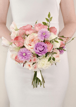 Artificial wedding bridesmaid bouquet held by a woman, with pink and purple faux roses, lilac daisies, white flowers and green leaves. Made in Melbourne by Flowers For Ever After, shipping Australia and Worldwide.