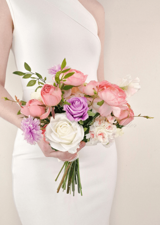 Artificial wedding bridesmaid bouquet, reverse view of pink and purple faux roses, white blooms and branching green leaves. Made in Melbourne by Flowers For Ever After, shipping Australia and Worldwide.