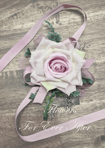 Artificial wedding wrist corsage with a pale lavender faux rose, small white flowers, green leaves and long ivory ribbons. For formals, proms and ball occasions. Made in Melbourne by Flowers For Ever After, shipping Australia and Worldwide.