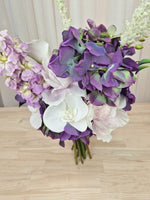 A mixed artificial floral bouquet with purple and white flowers, including a large purple chrysanthemum, white orchids, white calla lilies, and purple delphiniums.  Made in Melbourne Australia, by Australia's best silk bridal florist