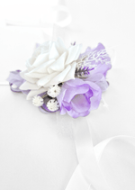 Artificial wedding wrist corsage, side view of white and lilac faux roses, tiny white flowers, purple sprigs and white ribbons. For formals, proms and ball occasions. Made in Melbourne by Flowers For Ever After, shipping Australia and Worldwide.