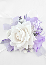 Artificial wedding wrist corsage with white and lilac faux roses, tiny white flowers, purple sprigs and white and lilac ribbons. For formals, proms and ball occasions. Made in Melbourne by Flowers For Ever After, shipping Australia and Worldwide.
