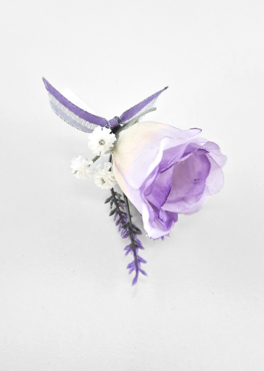Artificial wedding boutonniere, overhead view of a lilac faux rosebud, tiny white flowers, purple sprigs and purple ribbon. For formals, proms and ball occasions. Made in Melbourne by Flowers For Ever After, shipping Australia and Worldwide.