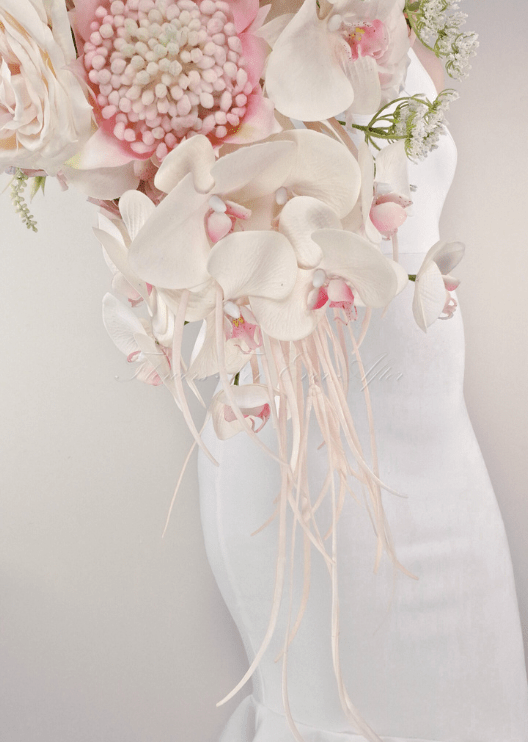 Artificial wedding cascading bridal bouquet with white faux orchids and green leaves, finished with wrapped stems. Made in Melbourne by Flowers For Ever After, shipping Australia and Worldwide.