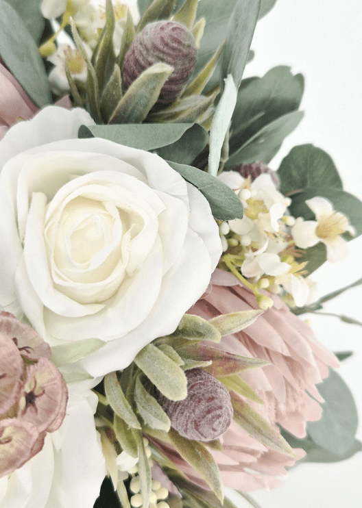 Artificial wedding bouquet close-up showing an ivory faux rose, blush pink protea, grey seedpods and cream flower sprigs. Made in Melbourne by Flowers For Ever After, shipping Australia and Worldwide.