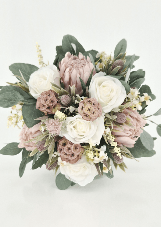 Artificial wedding bridal bouquet, overhead view of ivory faux roses, blush pink proteas, tan lotus pods, grey seedpods and eucalyptus. Made in Melbourne by Flowers For Ever After, shipping Australia and Worldwide.