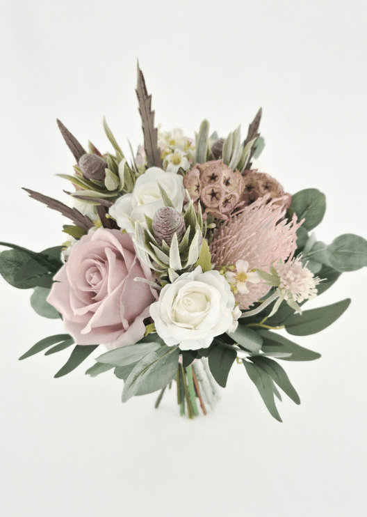 Artificial wedding bridesmaid bouquet with blush and ivory faux roses, pink spiky bloom, tan lotus pods, grey seedpods and eucalyptus. Made in Melbourne by Flowers For Ever After, shipping Australia and Worldwide.