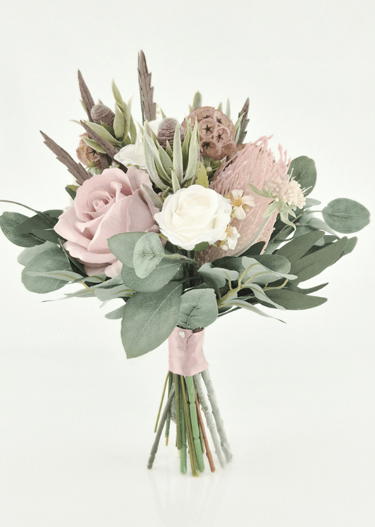 Artificial wedding bridesmaid bouquet, angled view of blush and ivory faux roses, pink spiky bloom, lotus pods and eucalyptus with blush-wrapped stems. Made in Melbourne by Flowers For Ever After, shipping Australia and Worldwide.