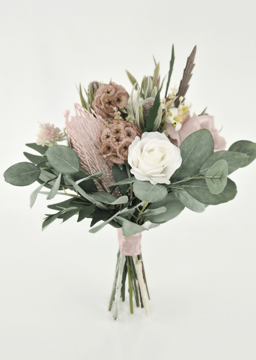 Artificial wedding bridesmaid bouquet with an ivory faux rose, pink spiky bloom, tan lotus pods, eucalyptus and blush-wrapped stems. Made in Melbourne by Flowers For Ever After, shipping Australia and Worldwide.