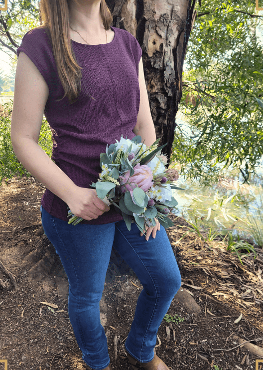 Artificial wedding hand-held bouquet, side view of ivory faux roses, blush pink protea, grey seedpods and eucalyptus. Made in Melbourne by Flowers For Ever After, shipping Australia and Worldwide.