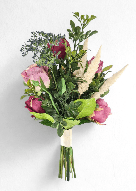 Artificial wedding small bouquet, reverse view of mauve and burgundy faux rosebuds, blue-grey berries, green foliage and pale plumes. Made in Melbourne by Flowers For Ever After, shipping Australia and Worldwide.