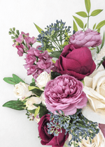 Artificial wedding bouquet close-up with burgundy faux rose, mauve ranunculus, ivory rosebuds, blue-grey berries and pink flower spikes. Made in Melbourne by Flowers For Ever After, shipping Australia and Worldwide.