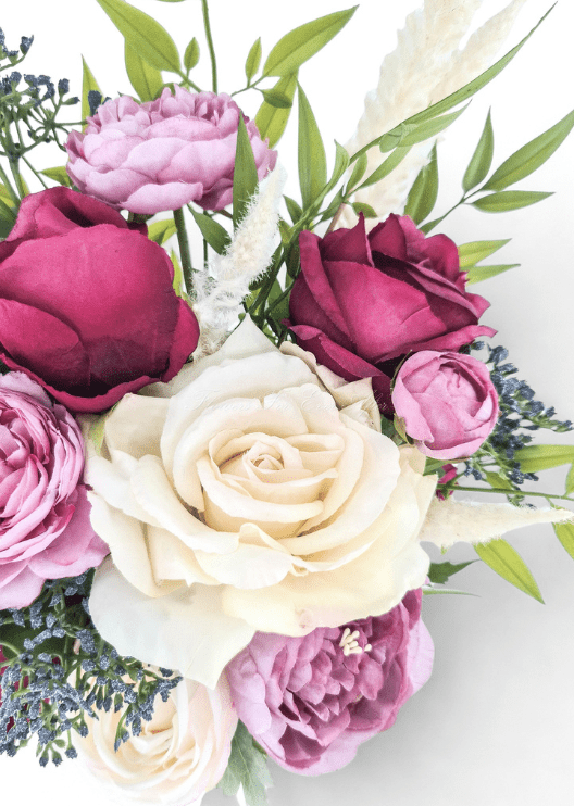 Artificial wedding bouquet detail showing an ivory faux rose, burgundy rosebuds, mauve blooms, blue-grey berries and pale plumes. Made in Melbourne by Flowers For Ever After, shipping Australia and Worldwide.
