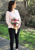 Artificial wedding bouquet held by a person, with burgundy and ivory faux roses, mauve blooms, green foliage and ivory ribbon tails. Made in Melbourne by Flowers For Ever After, shipping Australia and Worldwide.