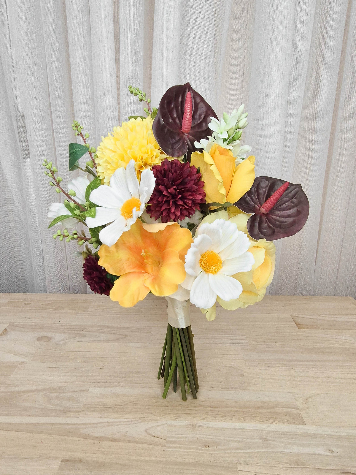A bright and boldly unique silk flower bridesmaid bouquet. Realistic yellow, whit and burgundy faux florals in an affordable design perfect for a small wedding or elopement or registry wedding.  Made in Melbourne Australia, by Australia's best bridal florist