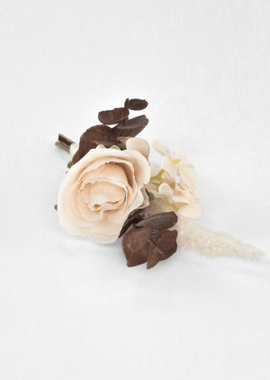 Artificial wedding boutonniere, overhead view of cream faux rosebud, brown and peach hydrangea and pale plume-like sprig. For formals, proms and ball occasions. Made in Melbourne by Flowers For Ever After, shipping Australia and Worldwide.