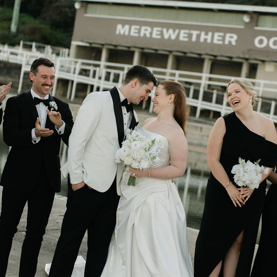 Bride & groom in black and white. Bride is holding a white artificial bridal bouquet and her bridesmaid hold a smaller size. Flowers by Flowers For Ever After