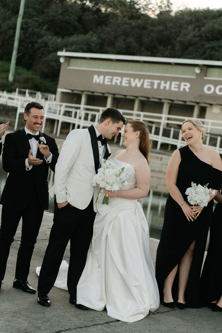 Bride & groom in black and white. Bride is holding a white artificial bridal bouquet and her bridesmaid hold a smaller size. Flowers by Flowers For Ever After