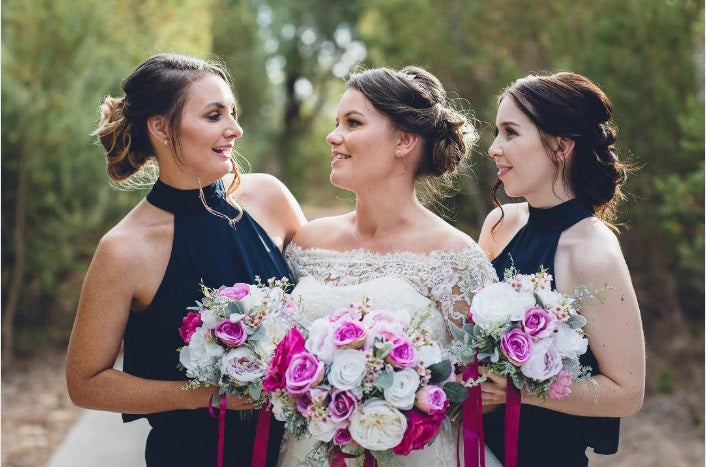 Bride with two bridesmaids holding faux bridal and bridesmaids bouquets in various pinks by Flowers For ever After