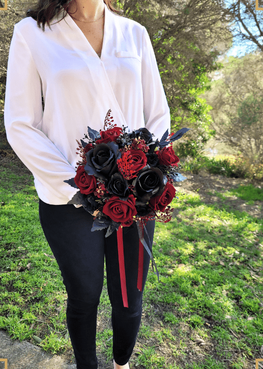 Artificial wedding bridal bouquet held in both hands, with mixed faux blooms, green foliage and trailing ribbon. Made in Melbourne by Flowers For Ever After, shipping Australia and Worldwide.