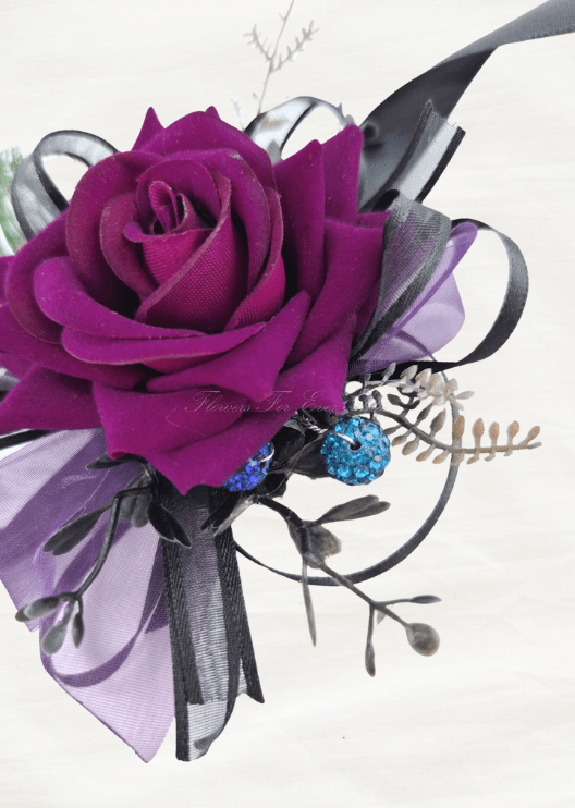 Artificial wedding corsage close-up with magenta faux rose petals, blue sparkling accents, dark sprigs and purple ribbon loops. For formals, proms and ball occasions. Made in Melbourne by Flowers For Ever After, shipping Australia and Worldwide.