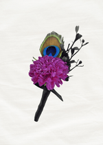 Artificial wedding boutonniere with a magenta faux pompom flower, peacock feather, black sprigs and black-wrapped stem. For formals, proms and ball occasions. Made in Melbourne by Flowers For Ever After, shipping Australia and Worldwide.