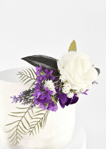 Artificial wedding cake topper detail showing a white faux rose, purple blossoms, tiny white flowers and fern-like greenery. For birthday, event and celebration cakes. Made in Melbourne by Flowers For Ever After, shipping Australia and Worldwide.