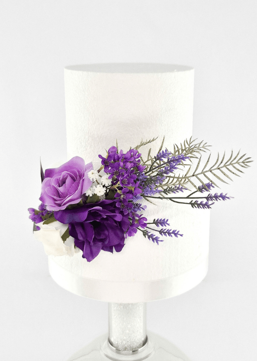 Artificial wedding cake decoration with purple and white faux roses, small purple flowers and fern-like foliage on the lower tier. For birthday, event and celebration cakes. Made in Melbourne by Flowers For Ever After, shipping Australia and Worldwide.