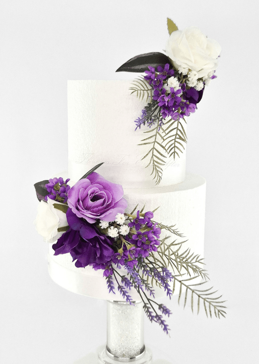 Artificial wedding cake decoration with purple and white faux roses, small purple and white flowers and fern-like leaves in two clusters. For birthday, event and celebration cakes. Made in Melbourne by Flowers For Ever After, shipping Australia and Worldwide.