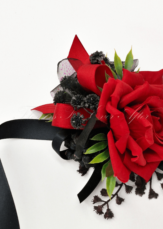 Artificial wedding wrist corsage, angled view of red faux roses, black ribbon loops and silver beads. For formals, proms and ball occasions. Made in Melbourne by Flowers For Ever After, shipping Australia and Worldwide.