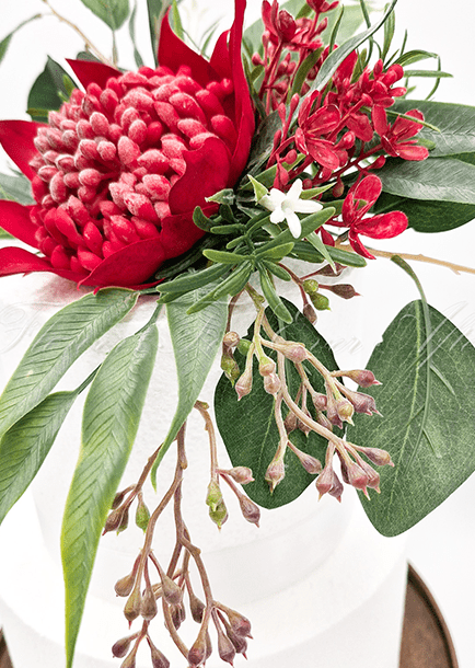Artificial wedding cake decoration, side view of red faux waratah, yellow wattle and native-style foliage. For birthday, event and celebration cakes. Made in Melbourne by Flowers For Ever After, shipping Australia and Worldwide.